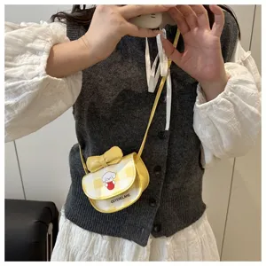 Primer plano de mini bolso bandolera amarillo a cuadros con perro de dibujos y lazo