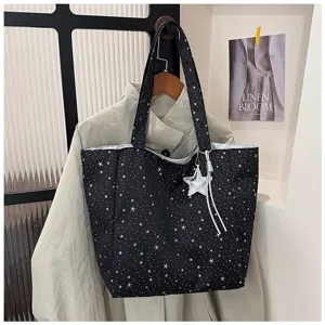 Detailed view of large black tote bag with silver star pattern and cute star charm.