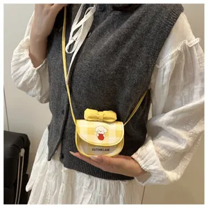 Detalle del mini bolso bandolera a cuadros con estampado de perrito y lazo amarillo en modelo.