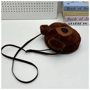 Detailed view of a cute brown furry plush bear head shape shoulder bag on white desk