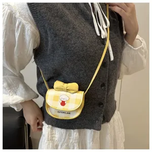 Detalle de un mini bolso bandolera de cuadros amarillos con un lindo perro de dibujos
