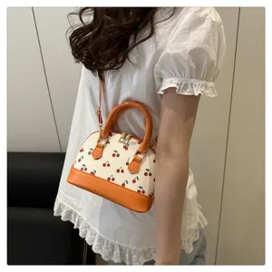 Lässige Lifestyle-Ansicht einer trendigen Muscheltasche mit Kirschdruck für Damen