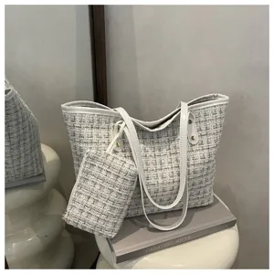 Detailopname van een witte tweed shopper tas met bijpassend klein ritszakje.