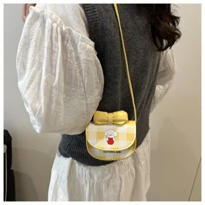 Vista detallada del mini bolso bandolera de cuadros amarillos con perro y lazo