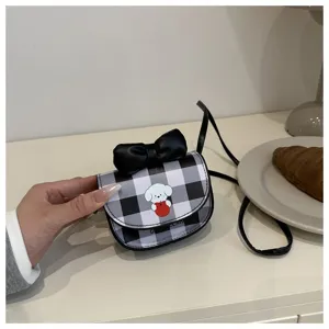 Primer plano de mini bolso bandolera a cuadros con estampado de perro y lazo negro