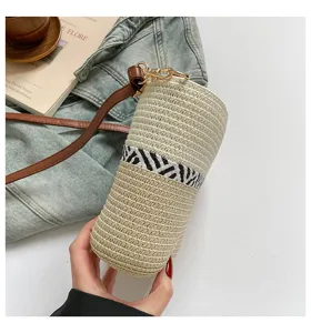 Primer plano de bolso cubo de paja tejida a mano con elegante banda de patrón cebra