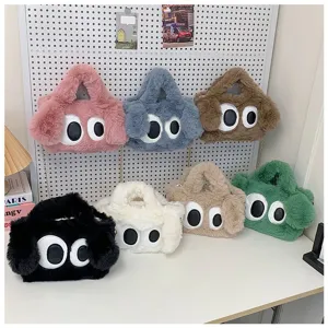 Bolsos de peluche de colores con grandes ojos de dibujos animados en un panel blanco