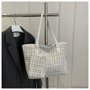 Elegante tweed geruite draagtas met bijpassend tasje hangend in een lifestyle-setting