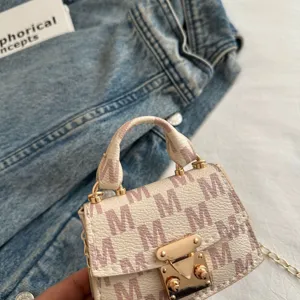 Close-up of luxury mini crossbody bag with purple M monogram pattern and gold chain.