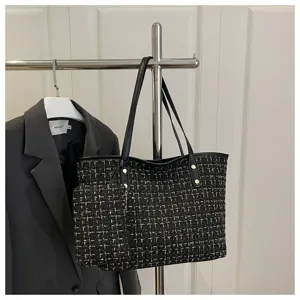 Gedetailleerde weergave van een grote tweed geruite draagtas met een klein bijpassend tasje