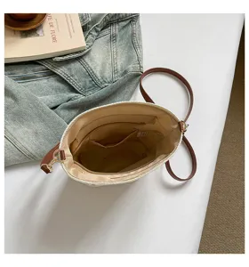 Detalle del interior espacioso con bolsillo con cremallera en un bolso de paja trenzada
