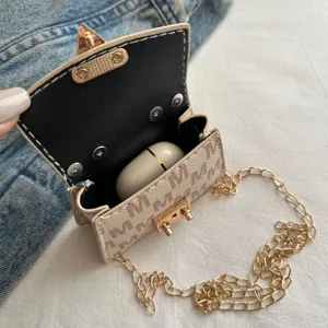 Close-up detail of a mini luxury crossbody bag with monogram pattern holding earbuds