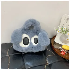 Vista detallada de la textura suave y el diseño de ojos de la bolsa de peluche azul