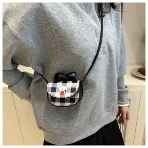 Bolso bandolera mini a cuadros con estampado de perro y lazo usado por una modelo