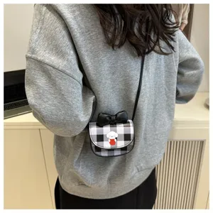 Vista de cerca de un mini bolso bandolera a cuadros con perro de dibujos y lazo