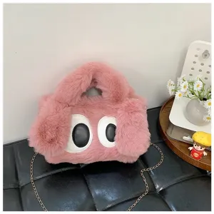 Vista detallada del bolso de peluche rosa con ojos grandes y cadena de metal oro