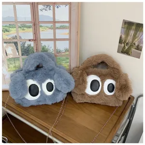 Vista detallada de dos lindos bolsos de peluche con ojos grandes y cadenas doradas