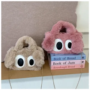 Primer plano de lindos bolsos de peluche rosa y beige con ojos grandes de dibujos animados