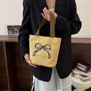 Bolso de lona amarillo informal con estampado de lazo negro y asas de tela marrón fuertes
