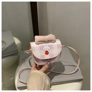Primer plano de mini bolso bandolera rosa a cuadros con lindo perro de dibujos y lazo
