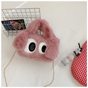 Vista detallada del bolso bandolera de felpa rosa con diseño de ojos grandes de dibujos