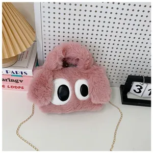 Detalle de un lindo bolso bandolera de felpa rosa con ojos grandes y cadena dorada.