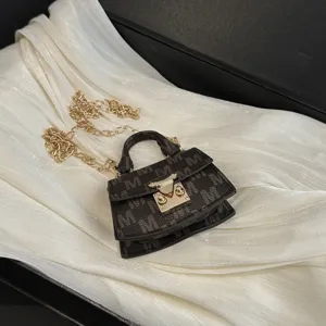 Close-up of a luxury mini monogram bag with gold chain and shimmering fabric backdrop