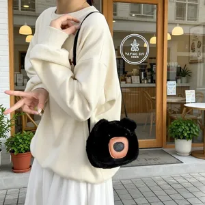 Cute black plush bear cartoon crossbody bag worn by a model in front of a cozy cafe