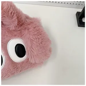 Detalle macro de bolso de peluche rosa con pelo sintético y bordado de ojos de dibujos