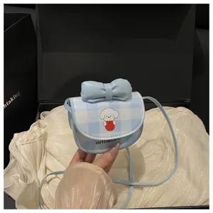Primer plano del mini bolso bandolera a cuadros azules con perro de dibujos y lazo