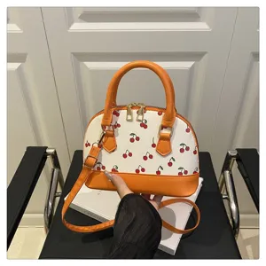 Detailansicht der Damen-Kirschdruck-Muscheltasche mit orangem Besatz.