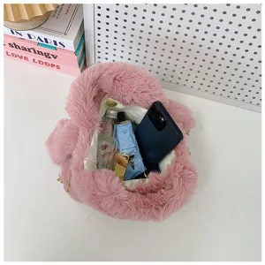 Vista detallada del interior de un bolso de felpa rosa con teléfono y cosméticos.