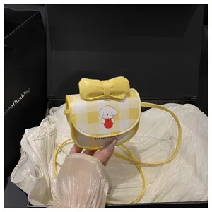 Primer plano de mini bolso de cuadros amarillo con perro de dibujos y un lazo