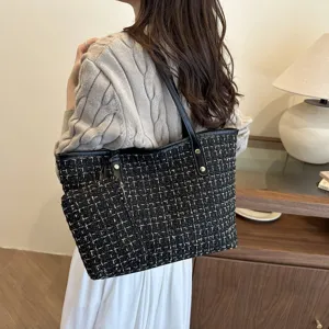 Elegante zwarte tweed geruite draagtas met bijpassend etui voor forenzende vrouwen.