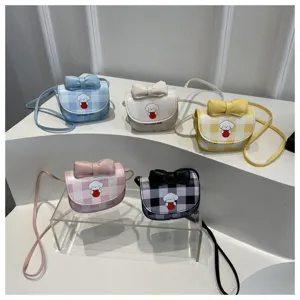 Primer plano de mini bolsos bandolera de cuadros con perros de dibujos animados y lazos.