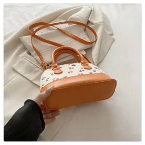 Detailansicht der orangefarbenen Kirsch-Muscheltasche mit Ledertextur und Boden
