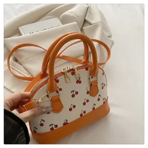 Nahaufnahme der schicken orange-weißen Kirschmuster-Muscheltasche mit Umhängeriemen