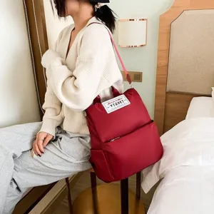 Rode multifunctionele Oxford-rugzak gedragen door een model in een slaapkamer
