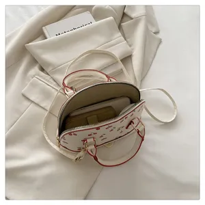 Detailansicht der weißen Muscheltasche mit Kirschmuster und Innenraum für Handy