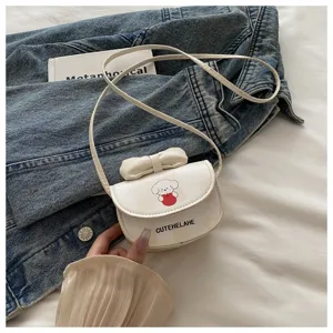 Primer plano de un mini bolso bandolera blanco con dibujo de perro y adorno de lazo