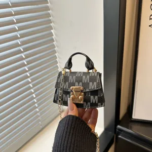Macro view of mini monogram handbag with elegant gold chain and secure clasp closure.