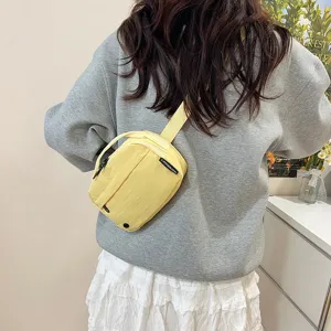 Bolso bandolera amarillo de tela Oxford impermeable usado por una modelo de diario