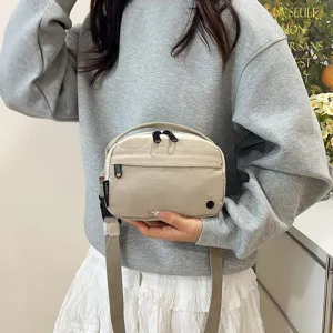 Primer plano de un bolso bandolera minimalista de tela Oxford impermeable sostenido por modelo