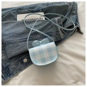 Primer plano detallado del mini bolso bandolera a cuadros azul claro con un lazo decorativo