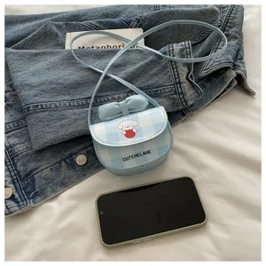 Bolso bandolera mini a cuadros con dibujo animado y lazo junto a un teléfono móvil