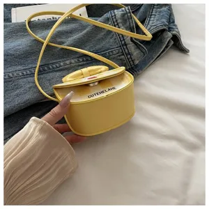 Detalle de un mini bolso bandolera amarillo con estampado de cuadros y un lazo