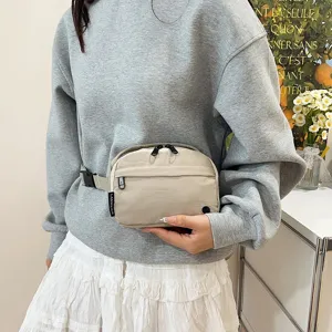 Primer plano de una riñonera minimalista de tela oxford beige con diseño impermeable