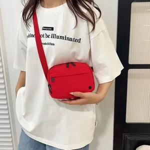 Detalle de un elegante bolso bandolera rojo de tela Oxford impermeable para mujer