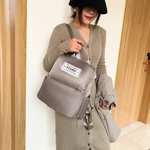 Stijlvolle taupe oxford stoffen rugzak voor dames nu gepresenteerd door een model