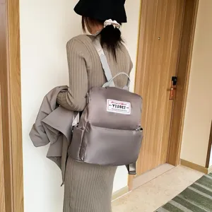 Stijlvolle taupe waterdichte Oxford stoffen rugzak voor dames getoond op een model
